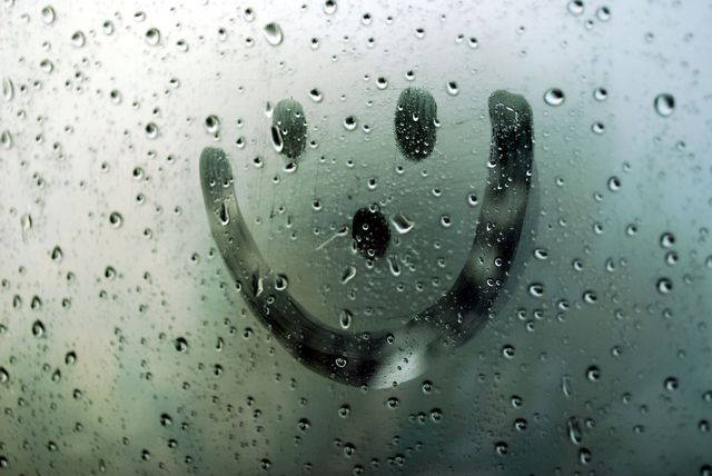 Smiley face on wet window from rain