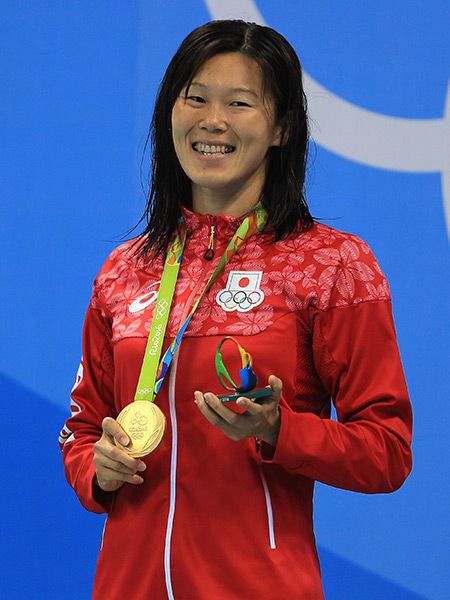 Sleeve, Hand, Award, Facial expression, Electric blue, Gold medal, Medal, Award ceremony, Long hair, Laugh, 