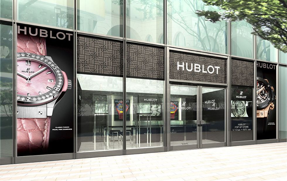 Glass, Commercial building, Facade, Clock, Advertising, Signage, Analog watch, Transparent material, Brand, Watch, 