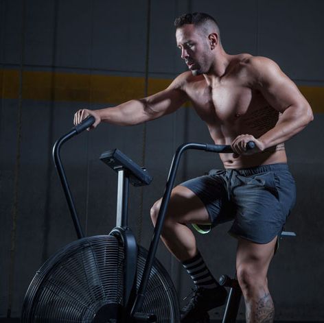 hombre fuerte que usa bicicleta de aire para hacer ejercicio