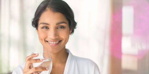 Woman smiling holding glass of water
