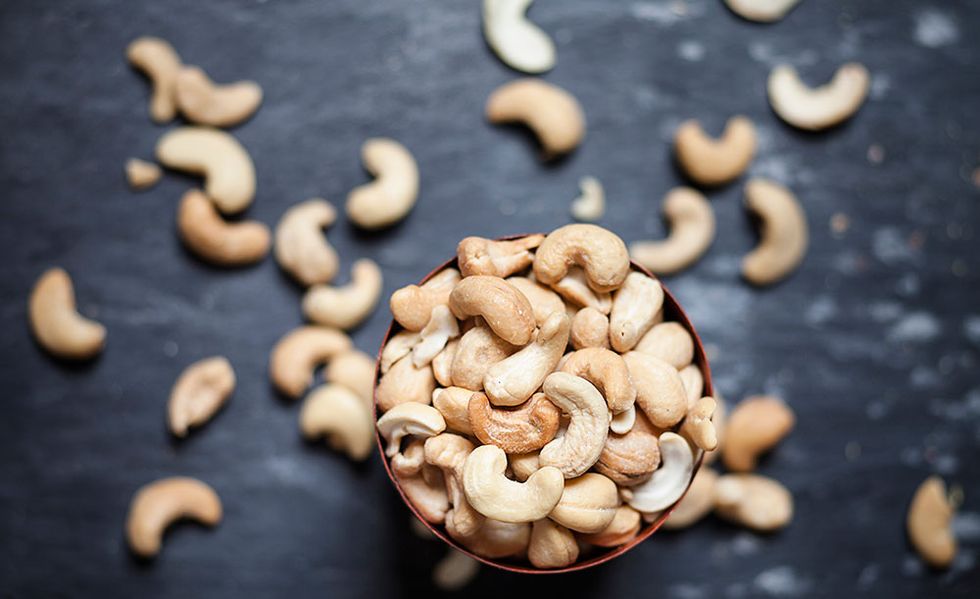 Bowl of roasted and salted cashew nuts on slate