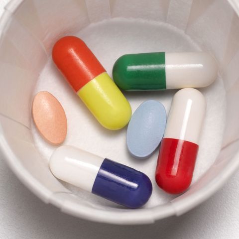 Pills and tablets and antibiotics in a paper cup