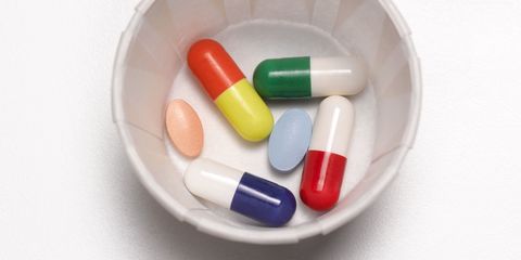 Pills and tablets and antibiotics in a paper cup