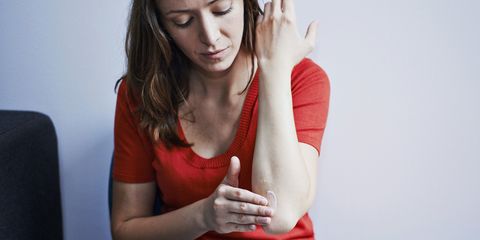 woman applying cream to elbow