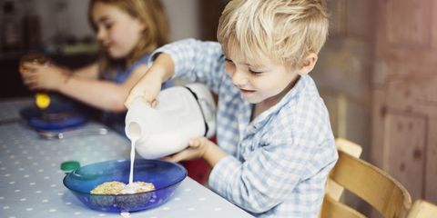 Little boy pouring milk