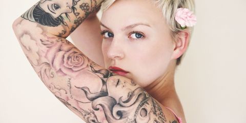 Heavily tattooed woman wearing a flower