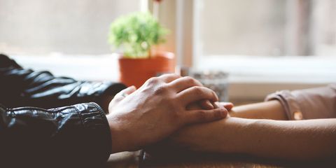 Close up couple holding hands on table