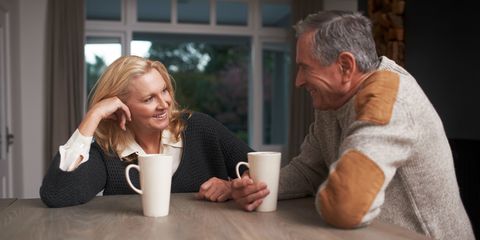 Older couple having coffee and chatting at table