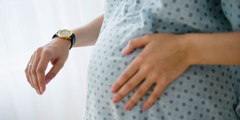 Pregnant woman timing contractions in hospital