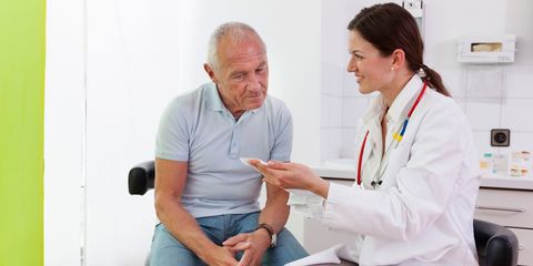 Female doctor talking to senior male patient