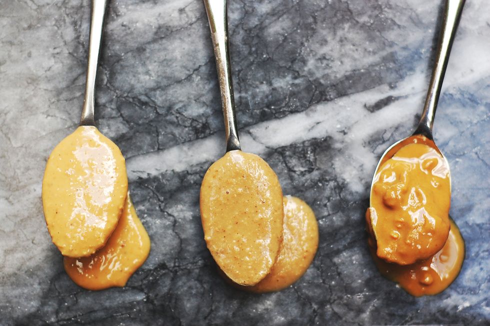 Close up of three varieties of nut butter on spoons