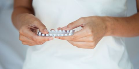 Woman holding birth control pills