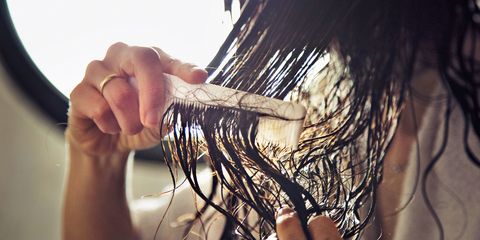 Closeup of the hands of a woman combing her hair