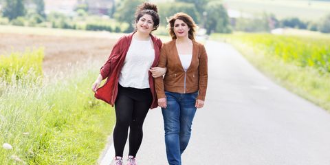 Mature mother and adult daughter walking together