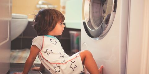 Small boy in front of washing machine