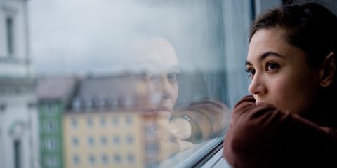 Young woman looking pensive window