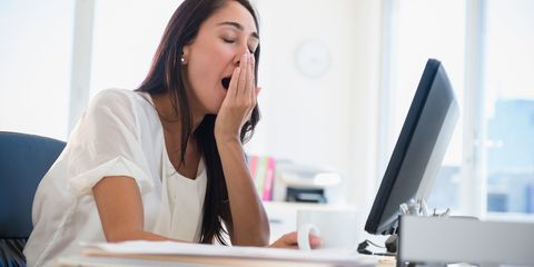 Businesswoman yawning at desk