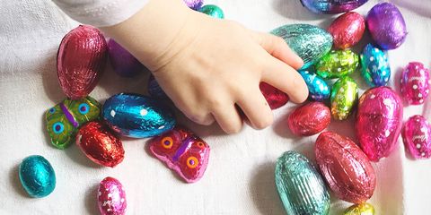 Small Girl Playing With Multi Colored Egg-Shaped Candies