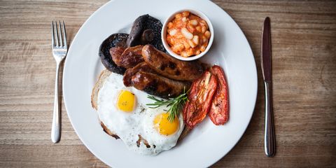 English breakfast: eggs on toast, sausage, bacon, beans, tomatoes, mushroom