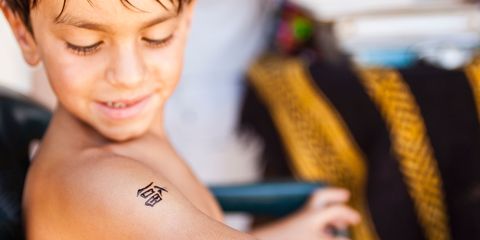 Boy looking at black henna temporary tattoo