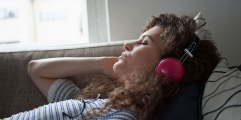 Woman wearing headphones asleep on sofa