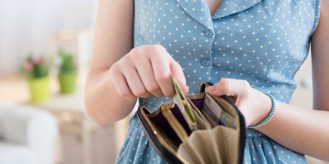 Woman putting money in purse