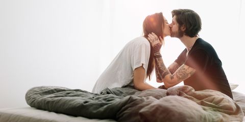 Young man and woman kissing in bed