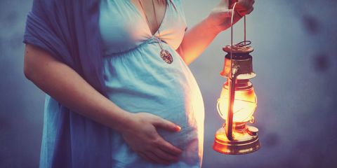 Pregnant woman holding lantern