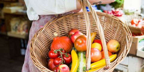 Woman holding basket with vegetables in farm shop