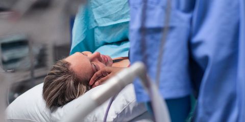 a Doula comforts a pregnant woman moments before her caesarean section.