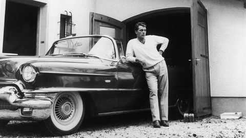 Welsh actor Richard Burton (1925 - 1984) stands next to a Cadillac and garage. (Photo by Hulton Archive/Getty Images)