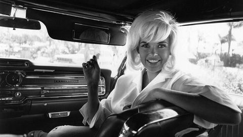 Vera Jane Palmer (1933 - 1967) better known as Jayne Mansfield, an American actress, in the passenger seat of a limousine. (Photo by Express Newspapers/Getty Images)