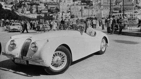 American actor Van Johnson, who became very popular during the war due to the absence of the established leading men, poses in his Jaguar XK120 parked in a crowded square. (Photo via John Kobal Foundation/Getty Images)
