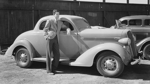 1st April 1936: American actor James Stewart (1908-1997) leaning against a '36 Plymouth. (Photo via John Kobal Foundation/Getty Images)