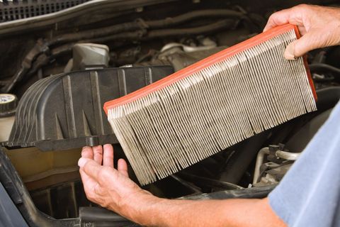Male Mechanic Hands Removing a Dirty SUV Air Filter