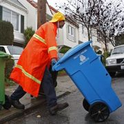 A Recology employee does recycling and trash pickups in San Francisco