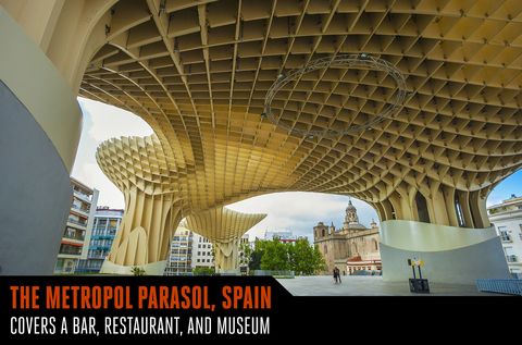 <p>Part work of art and part community structure, the Metropol Parasol in La Encarnacion Square in Seville, Spain, can make a case to be the world's largest wooden structure. It was designed by German architect Jurgen Mayer-Hermann, whose inspiration for the form came from nearby ficus trees and the Cathedral of Seville. The four-story whimsical flow of the structure covers more than 136,000 square feet, towering over a bar, restaurant, and museum.</p>