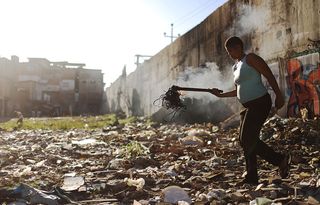 Claudia Rodrigues carries copper wire she burned to recycle in the Metro-Mangueira 'favela' community. The Olympics forced a relocation of many in the area, close to Maracana stadium.