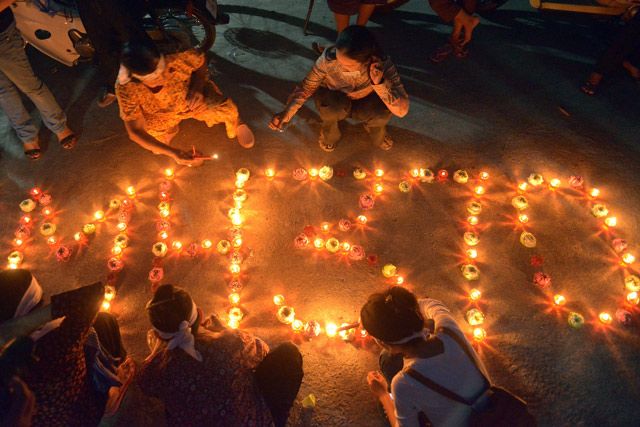 Cambodian residents of a community light candles as they pray for the missing Malaysia Airlines flight MH370 at their village in Phnom Penh on March 17, 2014.