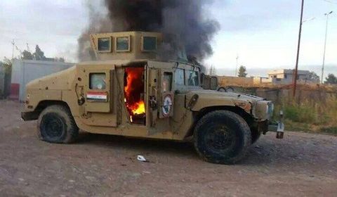 An armored vehicle belonging to Iraqi security forces in flames on June 10, 2014, after hundreds of militants from the Islamic State of Iraq and the Levant (ISIL) launched a major assault on the security forces in Mosul.
