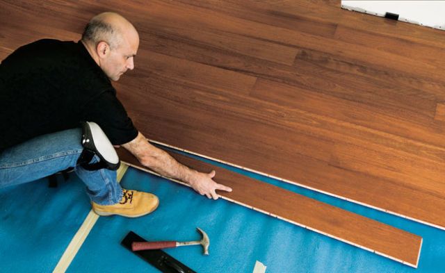 This floating floor is installed over a thin foam rubber pad. The 6-ft.-long planks lock together with tongue-and-groove joints.
