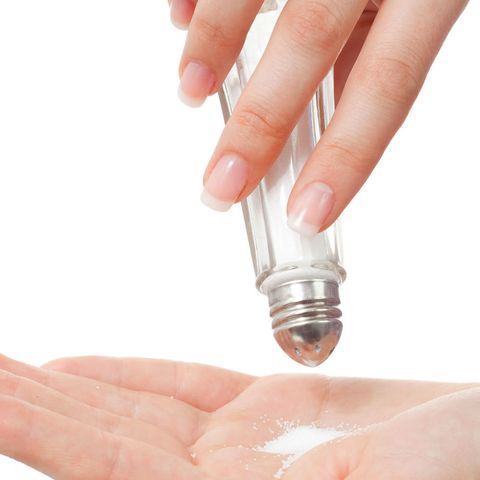 Woman shaking salt into hand