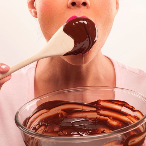 Woman licking chocolate from a spoon