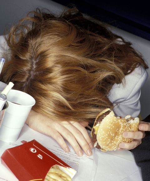 Tired woman eating junk food