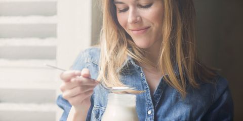 Woman eating dairy yoghurt smiling