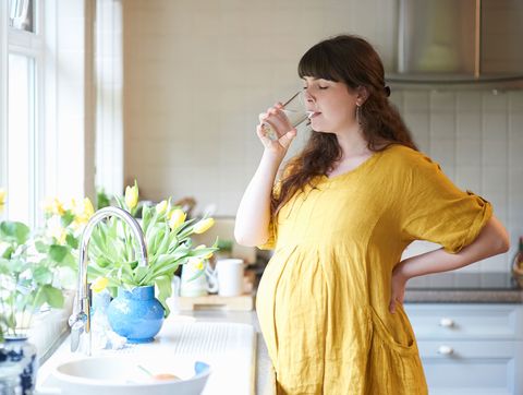 Pregnant woman having a drink of water