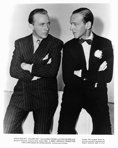 Bing Crosby and Fred Astaire with their arms folded staring at one an other in a scene from the film 'Holiday Inn', 1942.