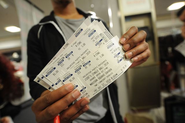 a man holds four concert tickets
