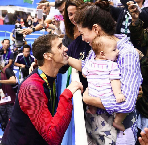 <p>What makes this adorable fam photo even better (besides the fact Micheal had just won gold)? Boomer's classy striped onesie.</p>